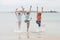 Group of three senior mature retired women on their 60s having fun enjoying together happy walking on the beach smiling playful