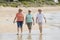 Group of three senior mature retired women on their 60s having fun enjoying together happy walking on the beach smiling playful