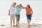 Group of three senior mature retired women on their 60s having fun enjoying together happy walking on the beach smiling playful