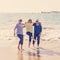 Group of three senior women walking having having fun on beach. Friendship and retirement lifestyle