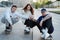 Group of three skaters posing together outdoors on sidewalk