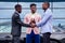 A group of three stylish African American businessman friends entrepreneurs fashion business suits meeting handshaking