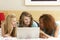 Group Of Three Teenage Girls Using Laptop In Bedro