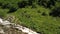 Group tourist with backpack to walk trail along rapid mountain stream