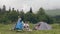 Group of tourist people resting in campsite while summer hiking in mountain