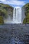 Group of tourists admiring the beauty of the Skogafoss waterfall in Iceland