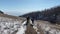 A group of tourists with backpacks walks along the trail to the frozen Lake Baikal.