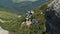 Group of Tourists and Children with Backpacks Go Down on Stone Trail in Mountain