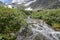 a group of tourists climbs to the top of the mountain, passing by a mountain river