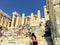 A group of tourists enter and take pictures at the entrance of the Acropolis lined with ancient doric columns