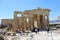 A group of tourists entering the Acropolis walking through the massive marble doric columns on a hot sunny summer day in Athens