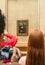 Group of tourists gathered around the Mona Lisa in the Louvre Museum.