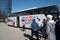 A group of tourists hurries to the two-story tour bus