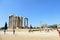 A group of tourists walking around admiring the remains of Temple of Olympian Zeus in Athens, Greece on a beautiful hot summer day