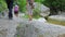 A group of tourists walks along the bottom of the canyon along a clean mountain river.