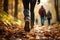 A group of tourists walks along the path of the autumn forest.