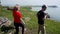 A group of tourists walks on top of a rocky hill and enjoys beautiful views.