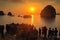 A group of tourists watching the sun set over Halong Bays magnificent seascape of limestone islands and karst mountains. Showcase