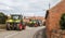 A group of tractors going through a village town