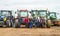 A group of tractors parked up with young farmers