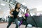 Group training with fitness loops in the gym, two young attractive athlete women doing crossfit with straps system. Sport,