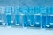 group of transparent plastic PET preforms are displayed on the shelf in blue background. industrial concept. selective focus