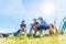 Group of travelers camping and doing picnic in meadow field fore