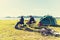 Group of travelers camping and doing picnic and playing music together. Mountain and lake background. People and lifestyle.