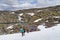 Group of travelers climbing on a snowy hill during a mountaineering adventure in the mountains. August 3, 2016 in Hardangervidda