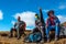 Group of Travelers resting on Mountain Footpath pointing Hand forward