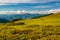 Group of trekkers hikers camping on grass meadow with view of Maramures ridge from Rodna Mountains, Muntii Rodnei National Park,