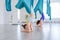 Group of two young yogi women doing antigravity yoga using blue hammock together