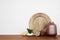 Group of various home decor objects on wood shelf against a white wall