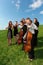 Group of violinists play standing on grass