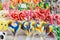 Group of vivid coloured sugar lollipops in display for sale at a candy store in individual plastic packaging, selective focus