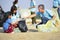 group of volunteers cleanup at the sand beach and adult help children collect and separate plastic bottle for reuse