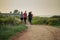 Group of walkers or hikers on a gravel path at a seaside, taking a walk in the evening. Group of people on an evening stroll