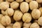 A group of walnuts in the shell a lot, the background wallpaper close-up. Nuts brown beige structured walnut shell texture.