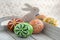 Group of wax painted Easter eggs on light grey tray, wax ornaments, painted flowers, rainbow colors