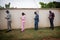 A group of well-dressed young Africans use their smartphones in line while keeping a safe distance during the pandemic