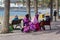 A group of West African sisters enjoy a well earned snack as the take a rest from their hair plaiting business for tourists on the