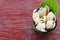 A group of white champaka with green leaf on banana leaf bowl