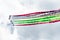 Group of white fighter jet airplane with a trace of colorful smoke against a blue sky.