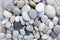 Group of white, grey and black pebbles, one by ony, simplicity stone background