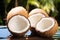 group of whole coconuts with one opened showing the water within