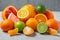 A group of whole and sliced citrus fruits - tangerines, lemons, limes, oranges, grapefruits on the surface of a gray