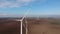 Group of wind driven generators stands among wide fields