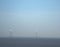 Group of windmills for power generation in the landscape against a blue sky