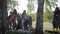 A group of women and children collect garbage in the forest. Volunteers collect plastic and other waste in black plastic