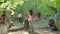 A group of women and children collect garbage in the forest. Volunteers collect plastic and other waste in black plastic